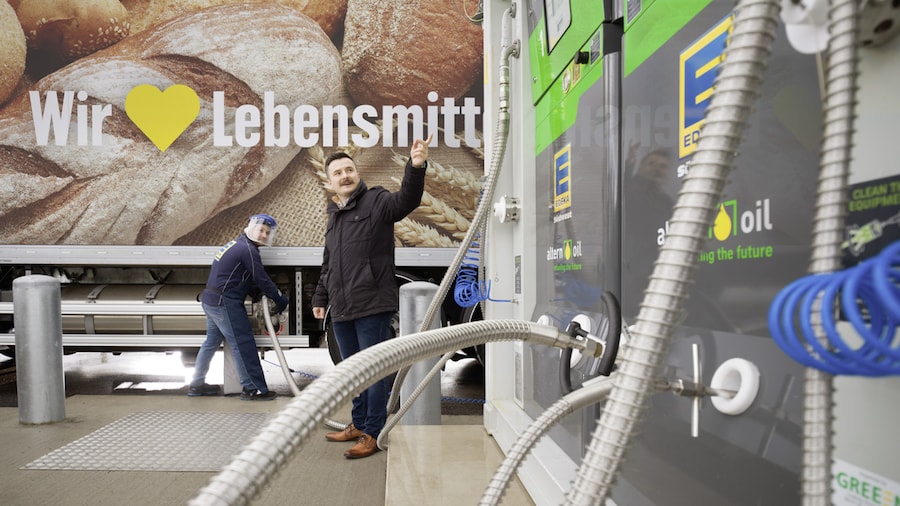 Zwei Männer beim Betanken eines Lkws an einer modernen Bio-LNG-Tankanlage.